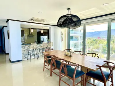 a dining room with a wooden table and chairs at Ocean View, Luxury Penthouse at Diamonte del Sol 702N in Jacó