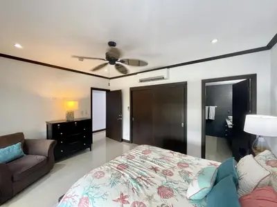 a bedroom with a bed and a couch and a ceiling fan at Ocean View, Luxury Penthouse at Diamonte del Sol 702N in Jacó
