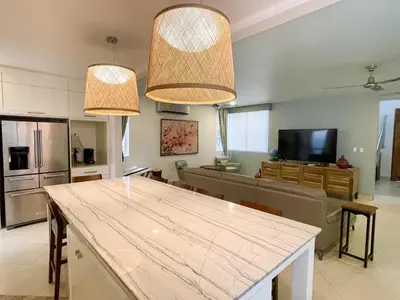a kitchen and living room with two chandeliers at Luxury Beachfront Oasis - Hermosa Palms 50 in Playa Hermosa