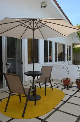 a table and two chairs and an umbrella on a patio at Luxury Beachfront Oasis - Hermosa Palms 50 in Playa Hermosa