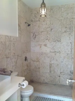 a bathroom with a toilet and a shower with a chandelier at Luxury Beachfront Oasis - Hermosa Palms 50 in Playa Hermosa