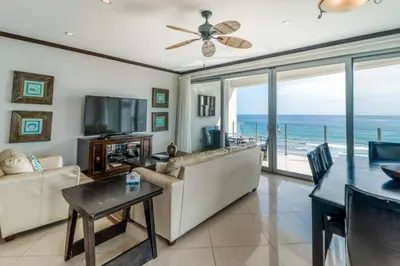a living room with a couch and a television and a table at Elegant Beachfront Condo at Diamonte del Sol - 801s in Jacó