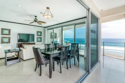 a dining room with a table and chairs and the ocean at Elegant Beachfront Condo at Diamonte del Sol - 801s in Jacó