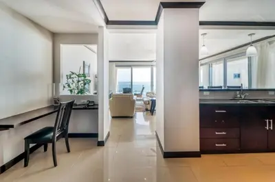 a kitchen with a desk and a dining room at Elegant Beachfront Condo at Diamonte del Sol - 801s in Jacó