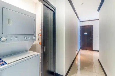 a room with a television and a hallway at Elegant Beachfront Condo at Diamonte del Sol - 801s in Jacó