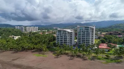 an aerial view of a city with palm trees and buildings at Elegant Beachfront Condo at Diamonte del Sol - 801s in Jacó