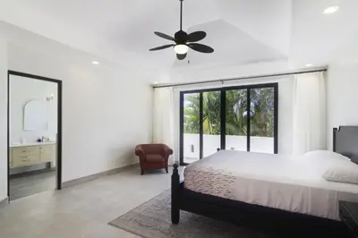 a bedroom with a bed and a ceiling fan at Classy Beachfront Home with Private Pool - Hermosa Palms 110 in Playa Hermosa