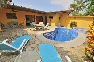 a patio with a pool and chairs and a table at Casa Suenos- Iconic 4BR Home with Private Pool in Jacó