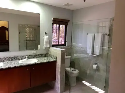 a bathroom with a sink and a shower and a toilet at Casa Suenos- Iconic 4BR Home with Private Pool in Jacó