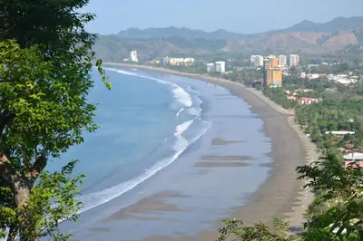 a view of a beach with a city in the background at Casa Suenos- Iconic 4BR Home with Private Pool in Jacó