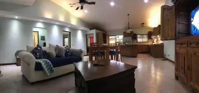 a living room with a couch and a table at Casa Suenos- Iconic 4BR Home with Private Pool in Jacó
