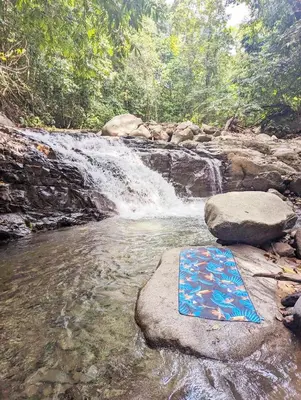 a waterfall with a painting on a rock in a river at Yogachal Vista Mar Bamboo House in the Jungle in Ojochal