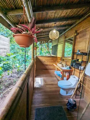 a bathroom with a toilet and a sink at Yogachal Vista Mar Bamboo House in the Jungle in Ojochal