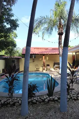 a villa with a swimming pool and palm trees at Coconut Beach House in Playa Conchal