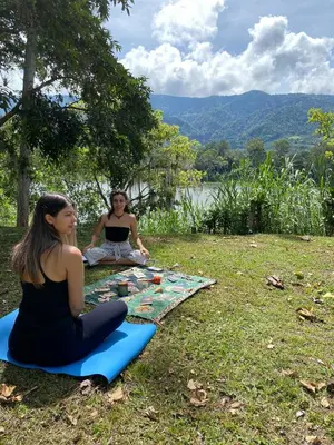 two women sitting on a blanket on the grass at Jicote finca de ecoturismo 2 in Cartago