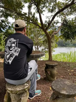 a man sitting on a stone bench looking at the water at Jicote finca de ecoturismo 2 in Cartago