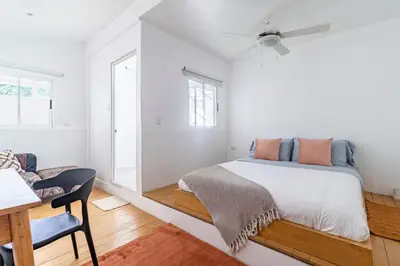 a white bedroom with a bed and a desk at Casa Bonimus in Santa Teresa Beach