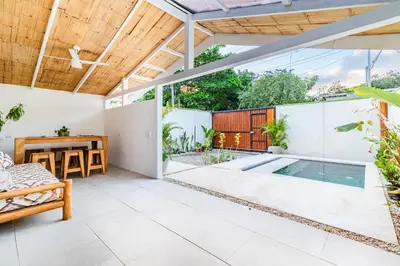 an outdoor patio with a swimming pool and a wooden ceiling at Casa Bonimus in Santa Teresa Beach