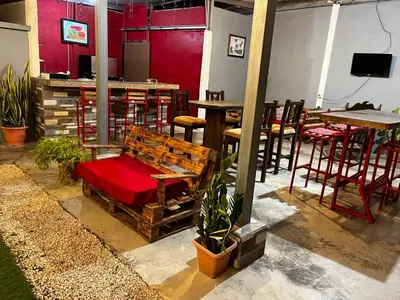 a restaurant with a bench and tables and chairs at Gamboa Lodging 1 in Liberia