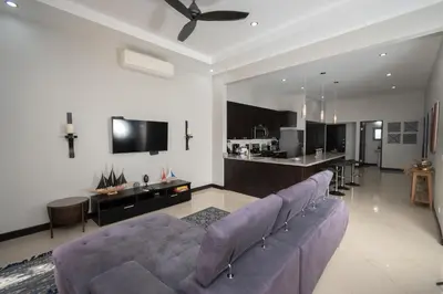 a living room with a couch and a kitchen at Casa Aqua in Tamarindo