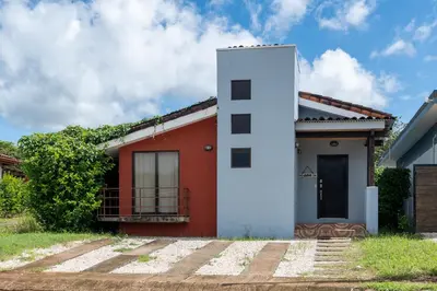 a red and white house with a black door at Casa Aqua in Tamarindo