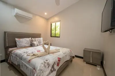 a bedroom with a bed and a window and a television at Casa Aqua in Tamarindo