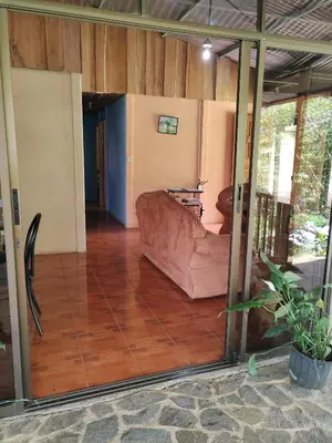 a living room with a couch and a glass door at Natural paradise in Turrialba