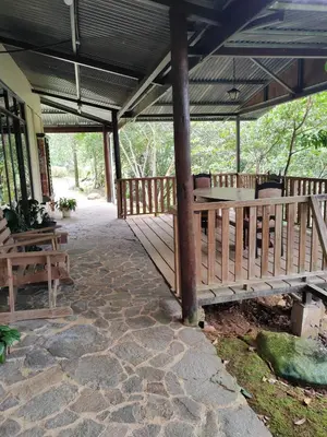 a wooden deck with a table and benches on it at Natural paradise in Turrialba