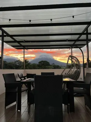 a table and chairs on a balcony with a view at Rooftop and stunning Arenal Volcano views 3 minutes from La Fortuna in Fortuna