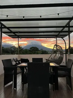 a patio with a table and chairs with a view at Rooftop and stunning Arenal Volcano views 3 minutes from La Fortuna in Fortuna