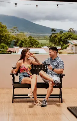 a man and a woman sitting on a bench at Rooftop and stunning Arenal Volcano views 3 minutes from La Fortuna in Fortuna