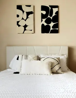a bedroom with a white bed with black and white pillows at Rooftop and stunning Arenal Volcano views 3 minutes from La Fortuna in Fortuna