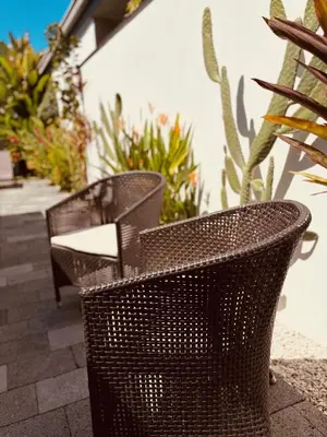 two wicker chairs sitting on a patio with plants at Casa Principe in Uvita