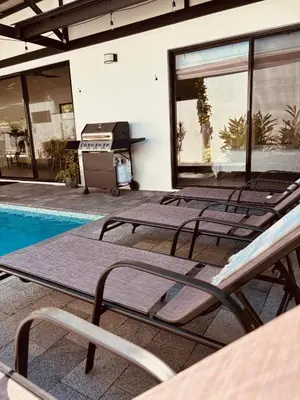 a row of chaise lounge chairs next to a swimming pool at Casa Principe in Uvita