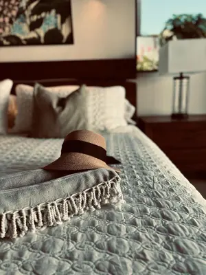 a hat sitting on top of a bed at Casa Principe in Uvita