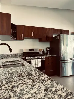 a kitchen with wooden cabinets and a stainless steel refrigerator at Casa Principe in Uvita