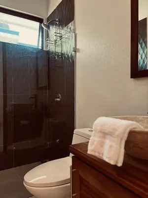 a bathroom with a toilet and a glass shower at Casa Principe in Uvita
