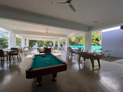 a pool table in a room with tables and chairs at Punta Esmeralda by Punta Leona in Jacó
