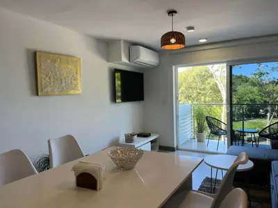 a dining room with a table and chairs and a window at Punta Esmeralda by Punta Leona in Jacó