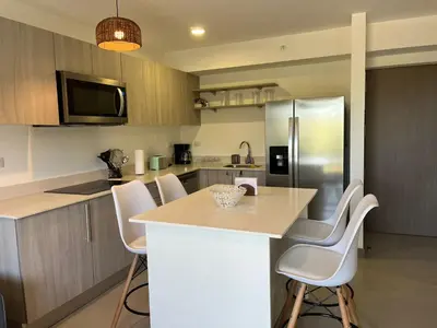 a kitchen with a counter and a refrigerator at Punta Esmeralda by Punta Leona in Jacó