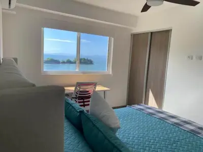 a bedroom with a bed and a large window at Punta Esmeralda by Punta Leona in Jacó