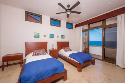a bedroom with two beds and a ceiling fan at Casa Del Mar- 3 Br Ocean View House In Flamingo in Playa Flamingo