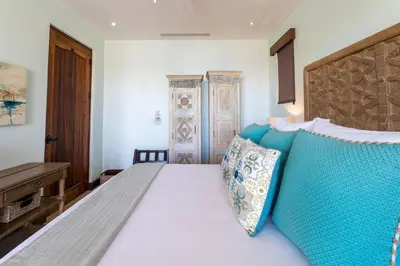 a bedroom with a bed with a blue headboard at Casa De Los Sueños - 3 Bedroom Home At Las Catalinas in Playa Danta