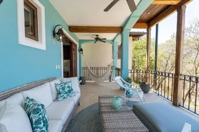 a living room with a couch and a balcony at Casa De Los Sueños - 3 Bedroom Home At Las Catalinas in Playa Danta