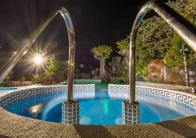 a swimming pool at night with a water slide at Hotel Le Priss in Manuel Antonio