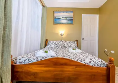 a bedroom with a wooden bed with flowers on it at Hotel Le Priss in Manuel Antonio