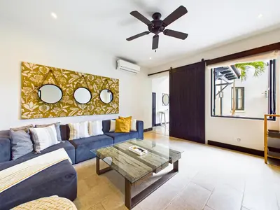 a living room with a blue couch and a ceiling fan at Casa Virginia #5 Private Pool -Ocean View At Las Catalinas in Playa Danta
