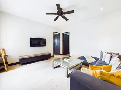 a living room with a blue couch and a ceiling fan at Casa Virginia #5 Private Pool -Ocean View At Las Catalinas in Playa Danta