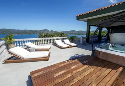 a deck with lounge chairs and a hot tub at 360 Splendor 407 -Ocean View -Breakfast Included! in Playa Flamingo