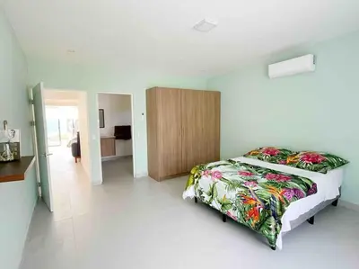 a bedroom with a bed and a wooden cabinet at Casa Pacifico 46 Tamarindo in Santa Cruz